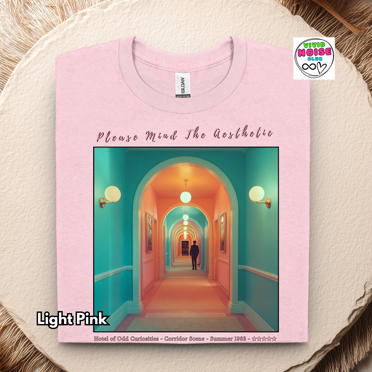 Light pink t-shirt with a colorful hallway design and text on a textured surface.