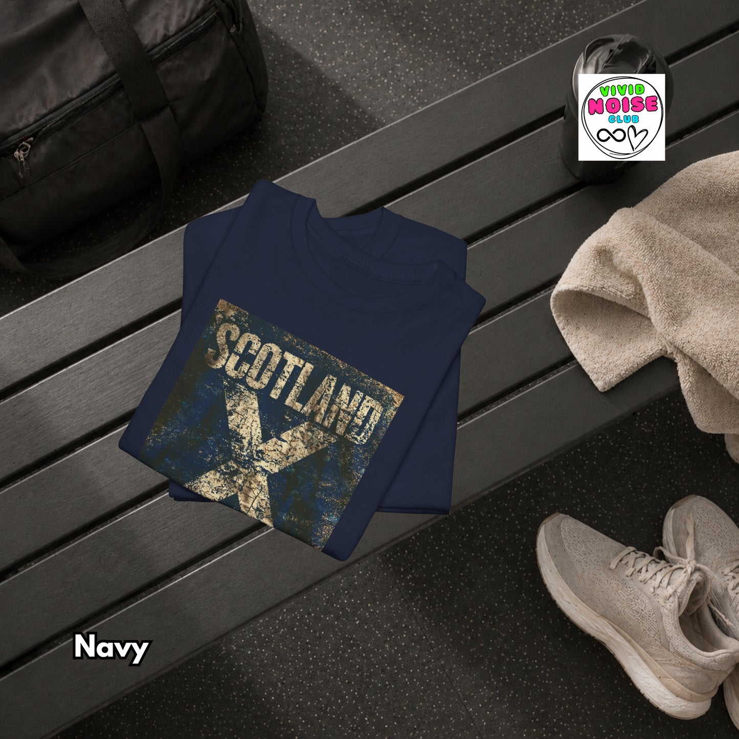 Navy t-shirt with 'Scotland' design on a bench, next to shoes and a bag.