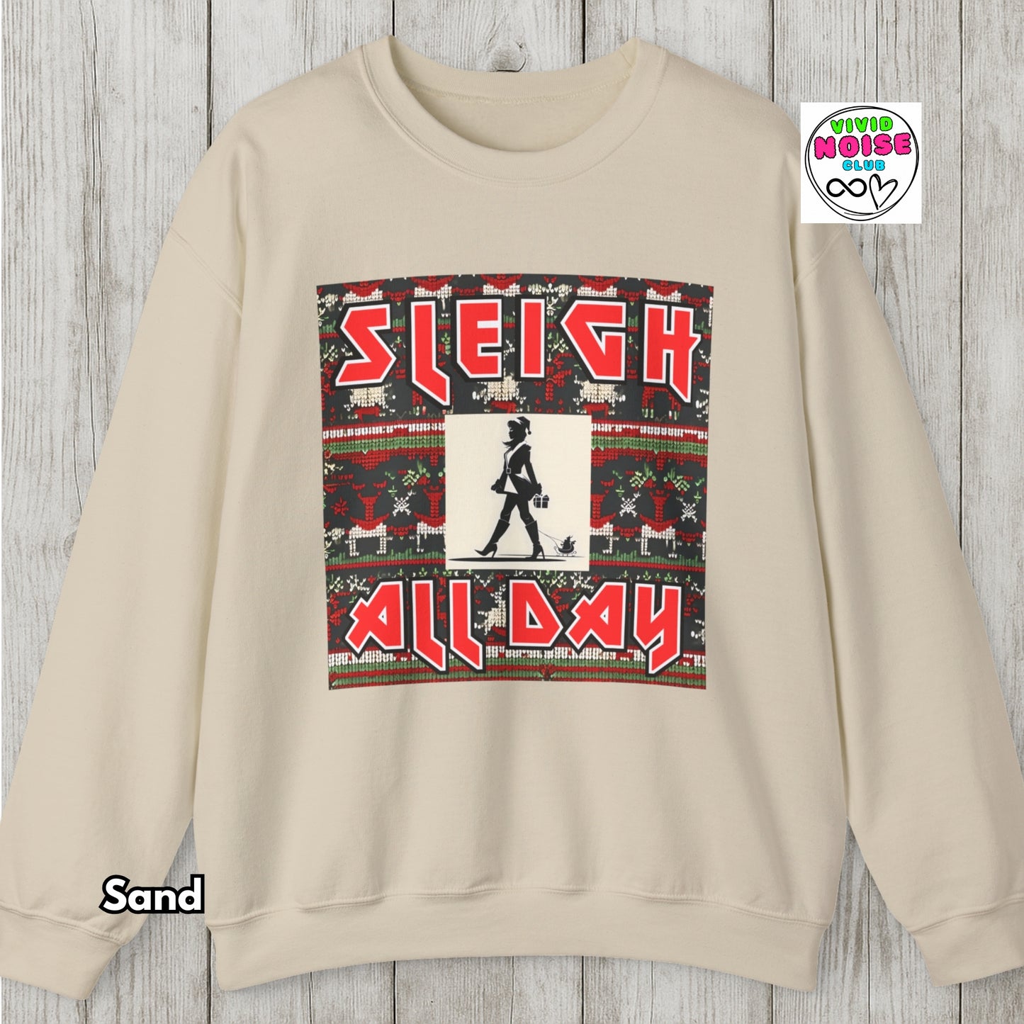 Beige sweatshirt with 'Sleigh All Day' graphic on a wooden surface, featuring the brand 'Viva La Vida'.