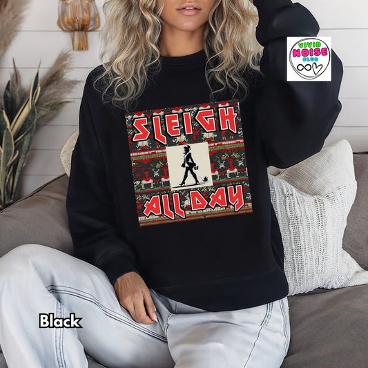 Person wearing a black sweatshirt with a festive design and text, sitting on a couch.