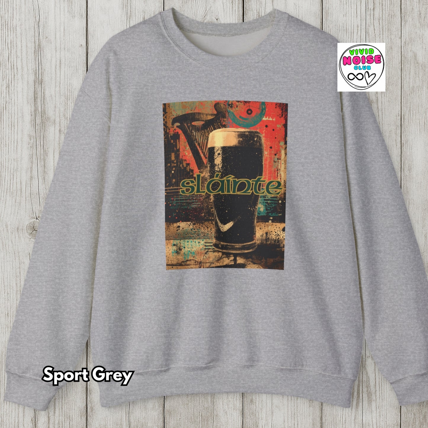 Gray sweatshirt with a graphic design of a glass of dark liquid and the word 'Slainte' on a wooden surface.