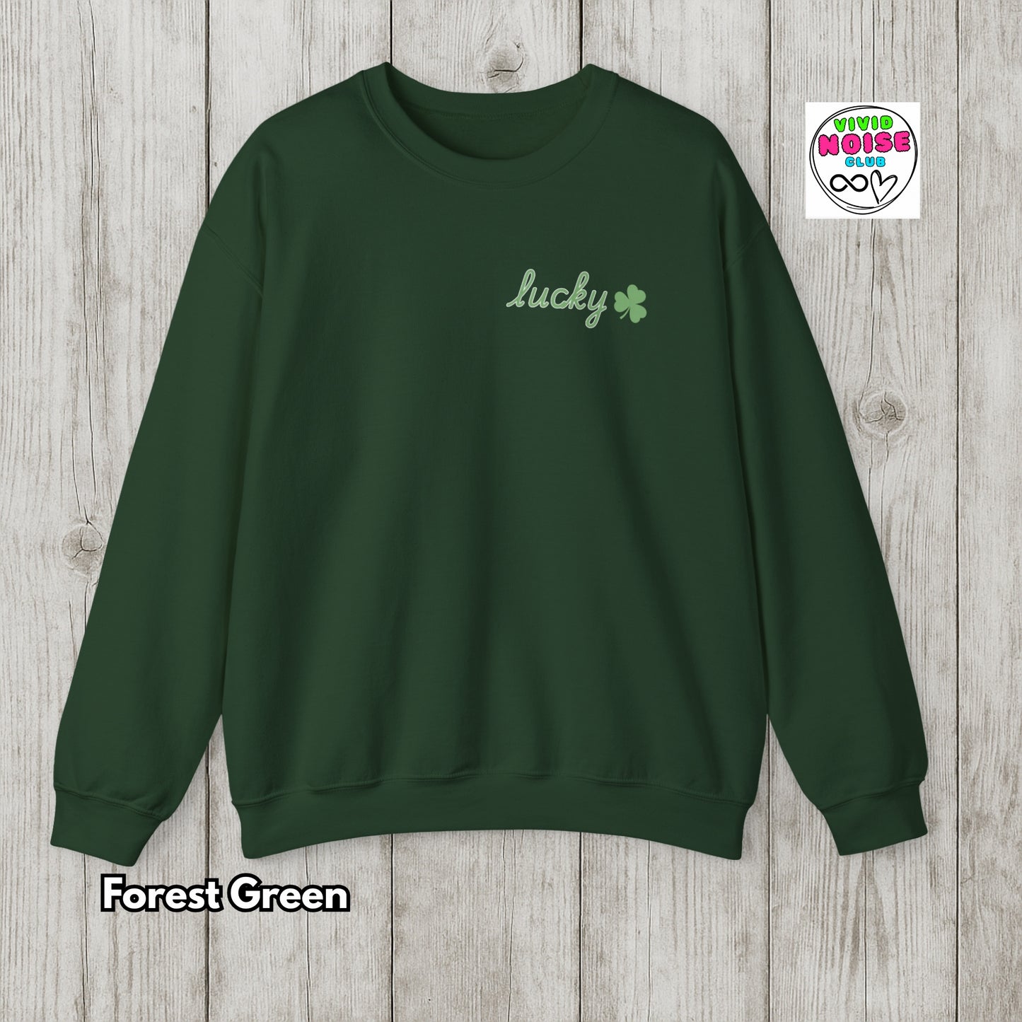 Forest green sweatshirt with 'lucky' and clover design on a wooden surface
