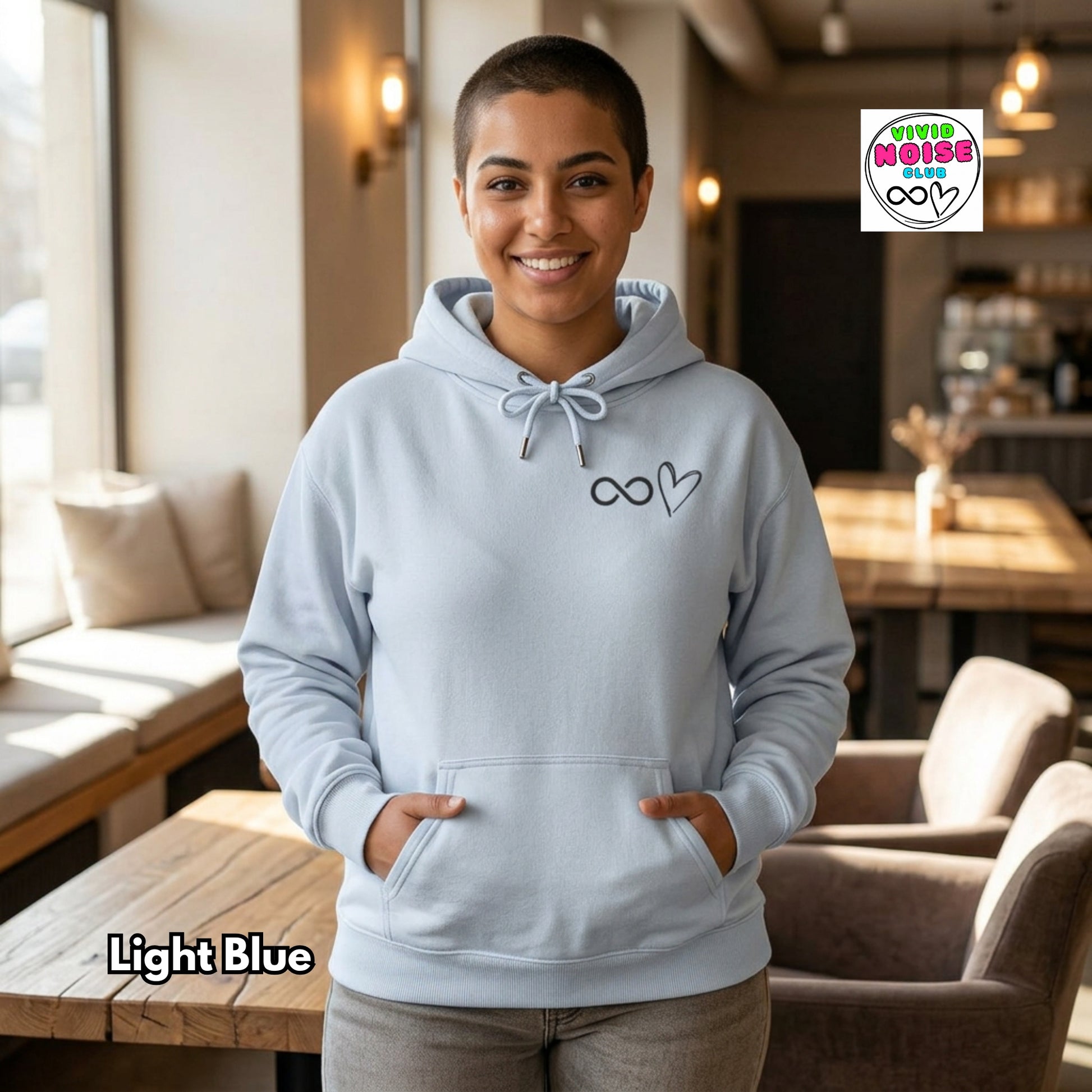 Person wearing a light blue hoodie with a logo in a casual indoor setting
