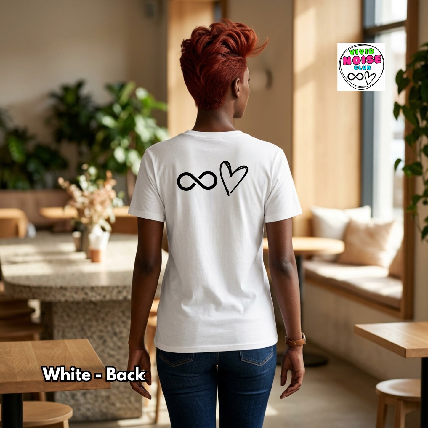 Person wearing a white t-shirt with a design on the back in a casual setting.