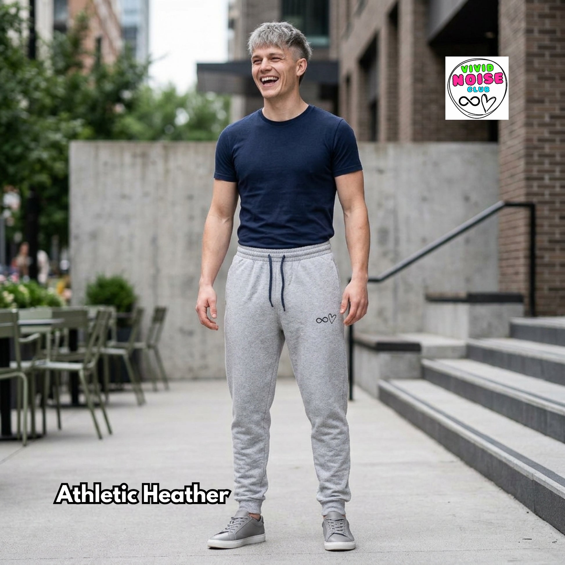 Man wearing athletic heather gray jogger pants standing outdoors with a building and trees in the background.