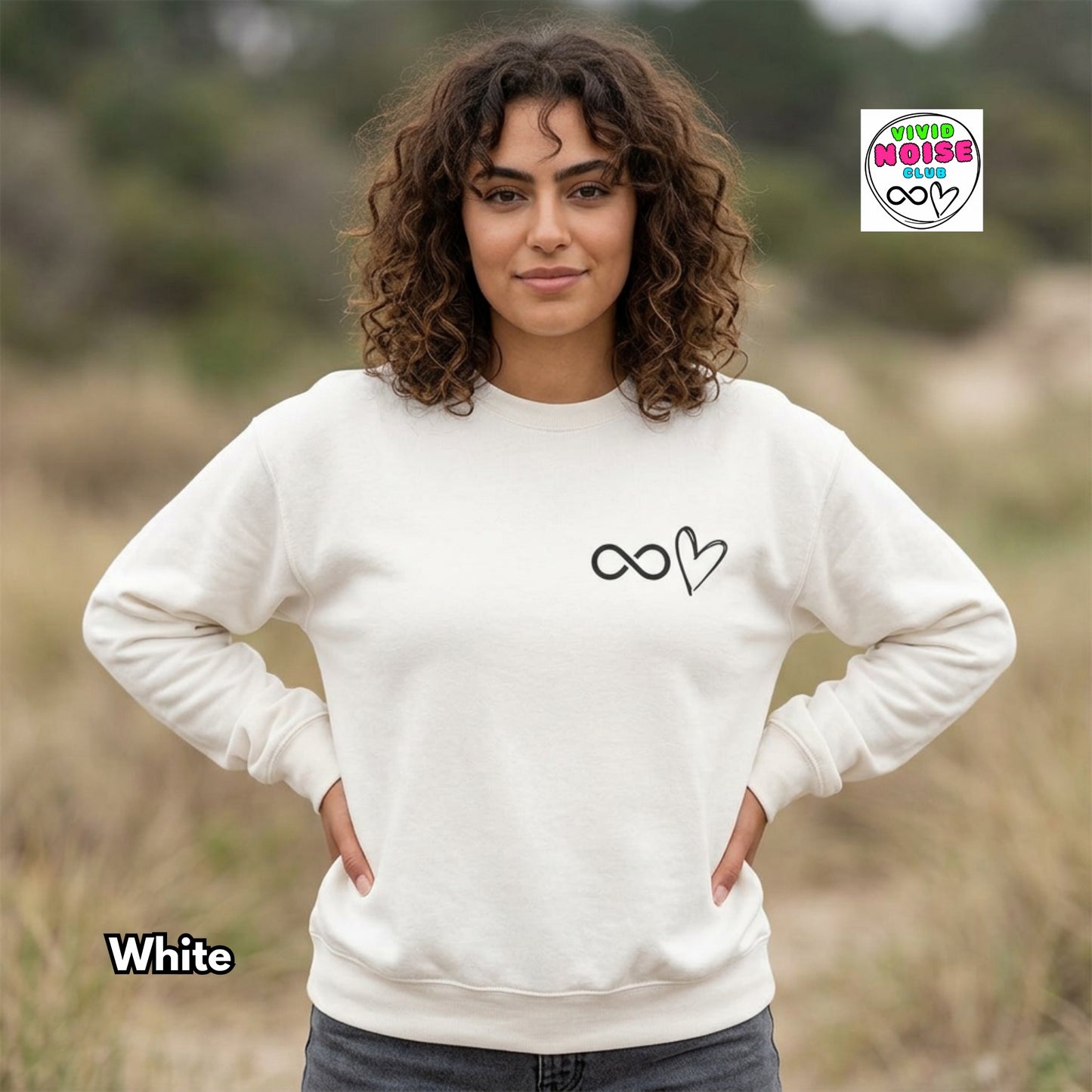 Woman wearing a white sweatshirt with a design in a natural setting