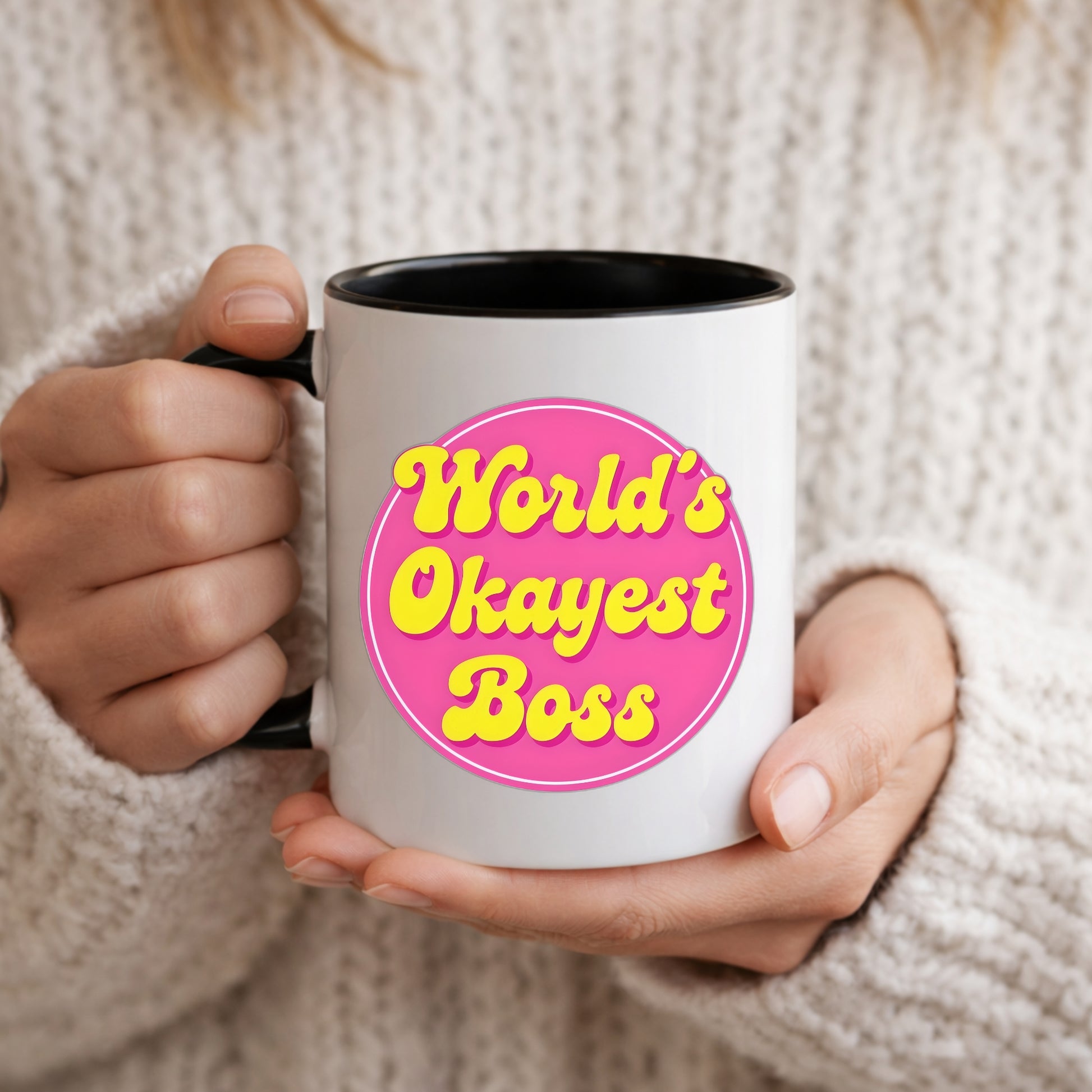 Person holding a mug with 'World's Okayest Boss' text