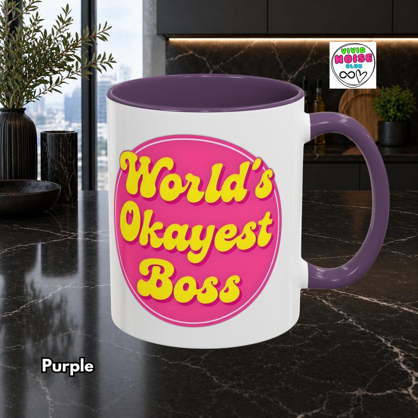Mug with 'World's Okayest Boss' text on a purple handle and interior, set against a modern kitchen background.
