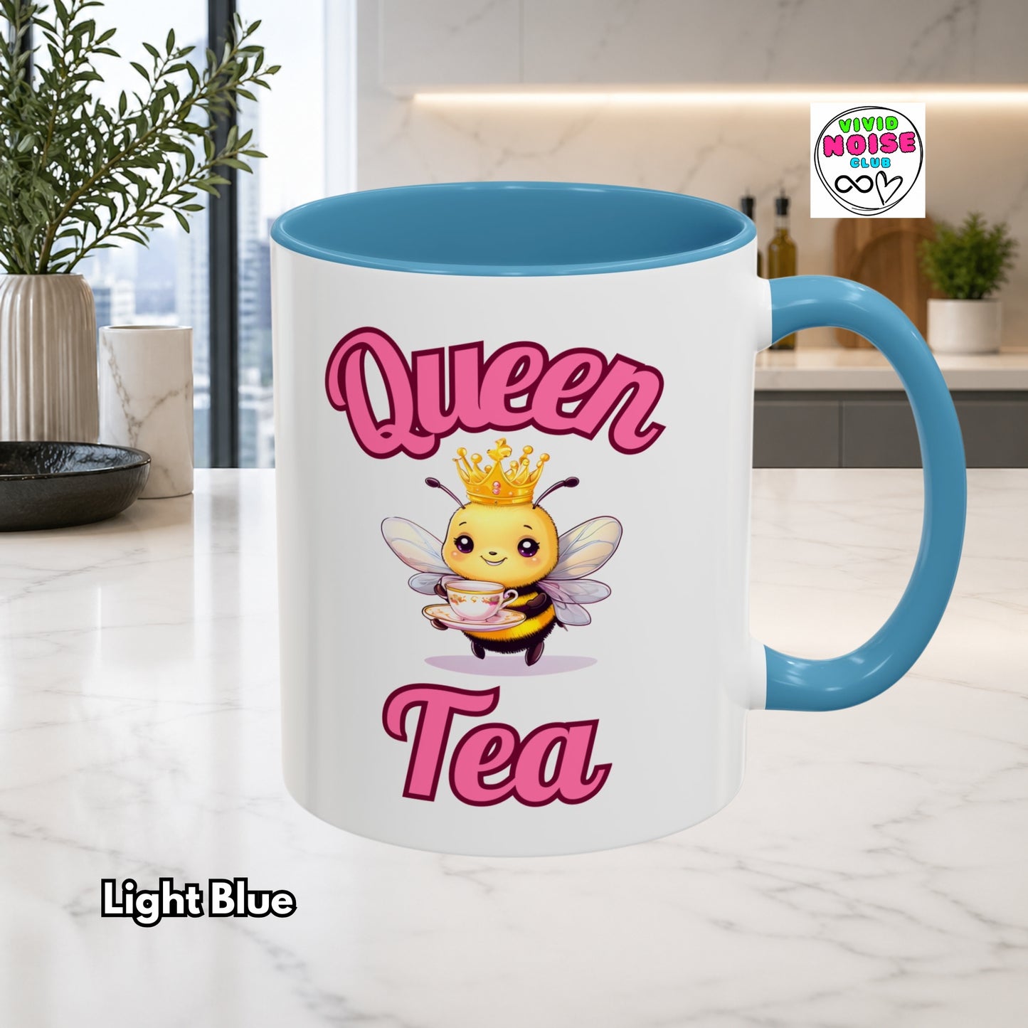 Mug with 'Queen Tea' design featuring a bee and crown, set against a kitchen background.