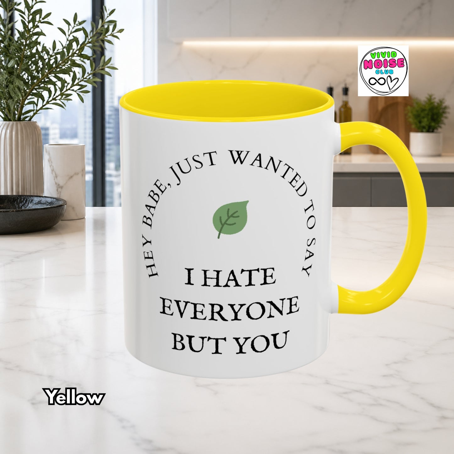 Mug with yellow interior and handle on a kitchen counter, featuring text and a leaf graphic.