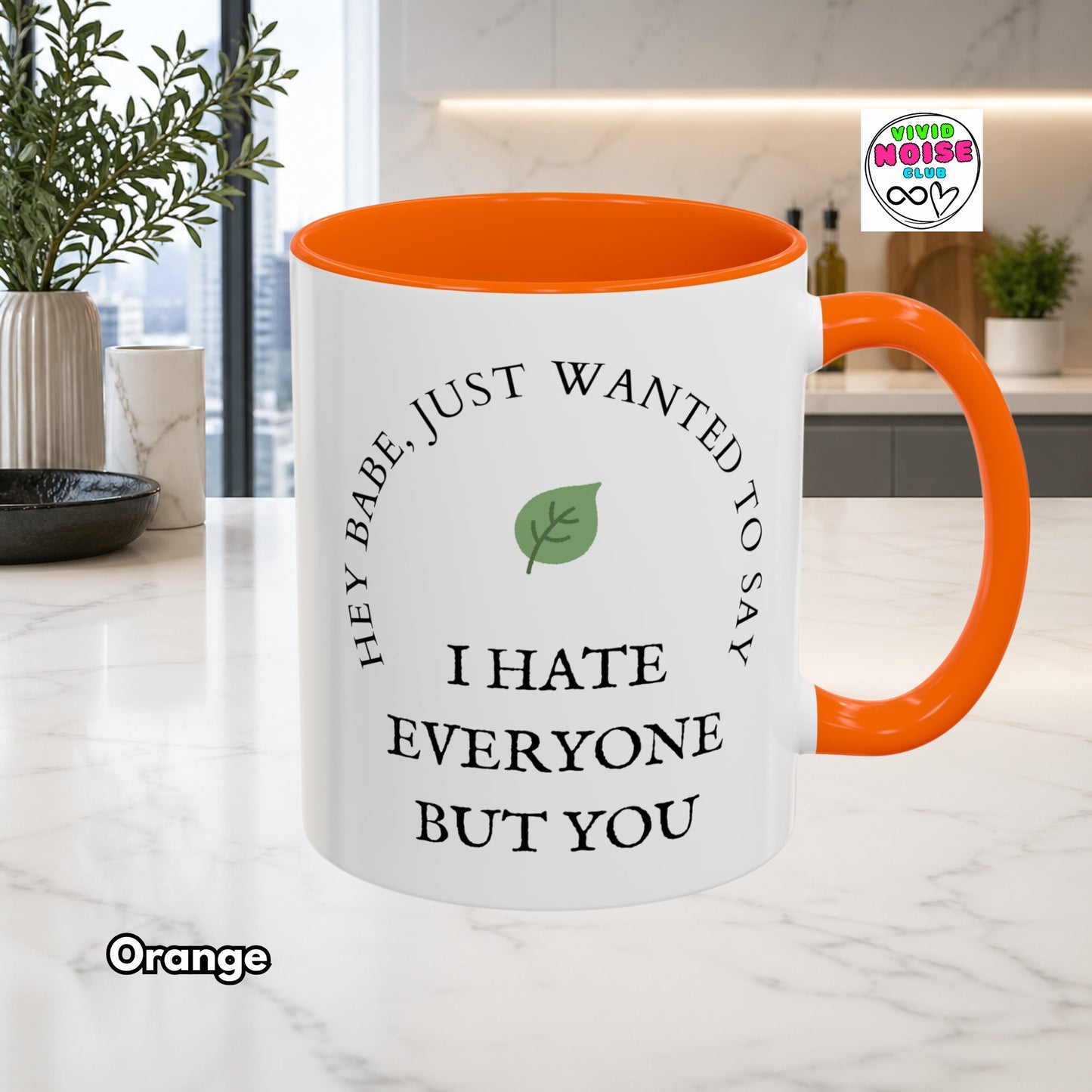 White mug with orange interior and handle, featuring a humorous message, on a kitchen counter.