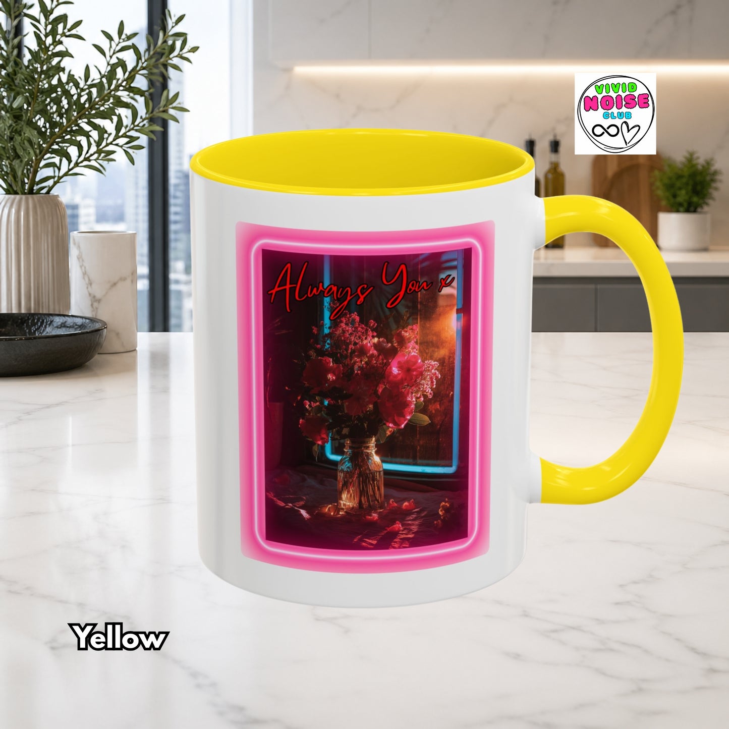 White mug with yellow handle and interior, featuring a pink neon-like border and floral design on a kitchen counter.