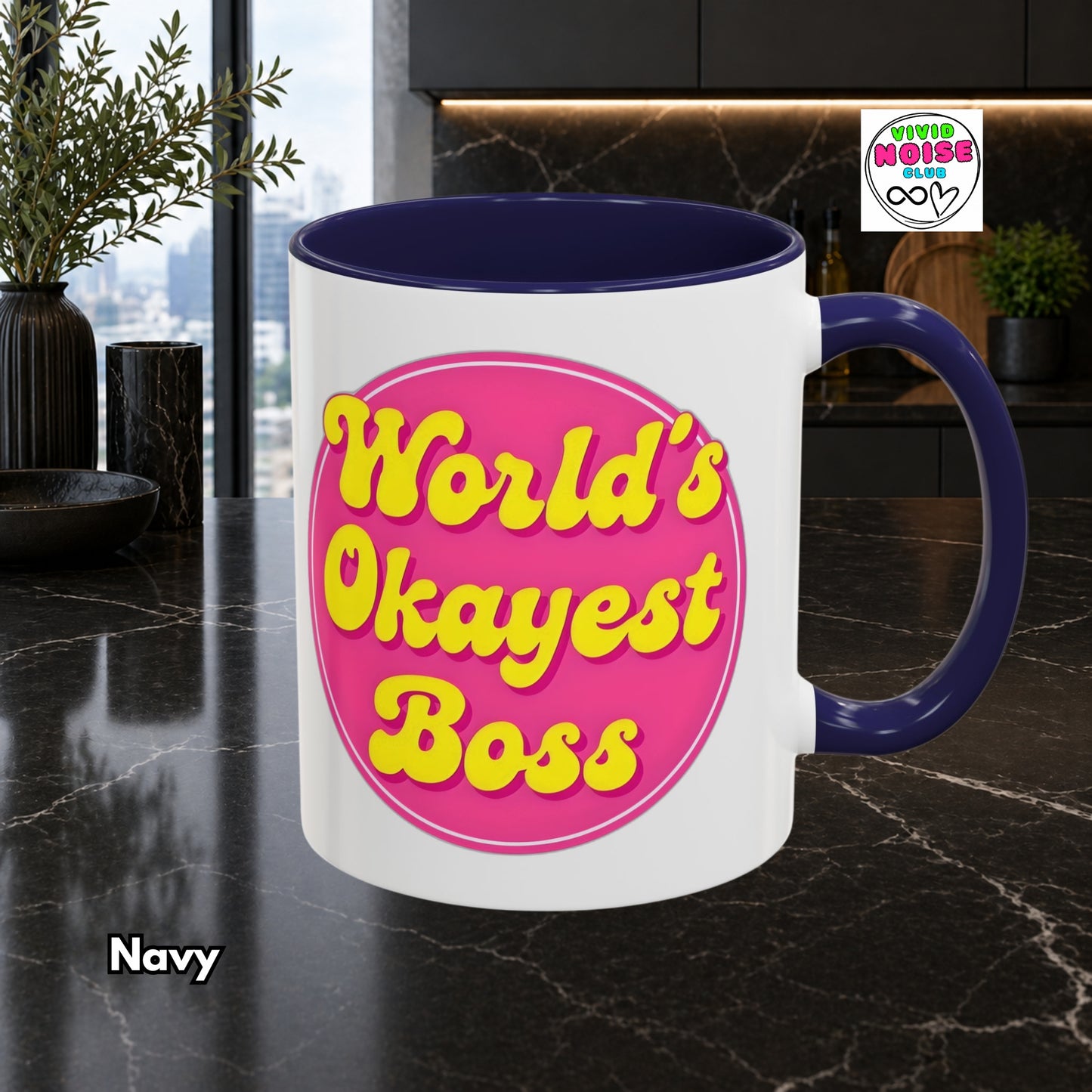 Mug with 'World's Okayest Boss' text on a dark surface, with a plant and window in the background.
