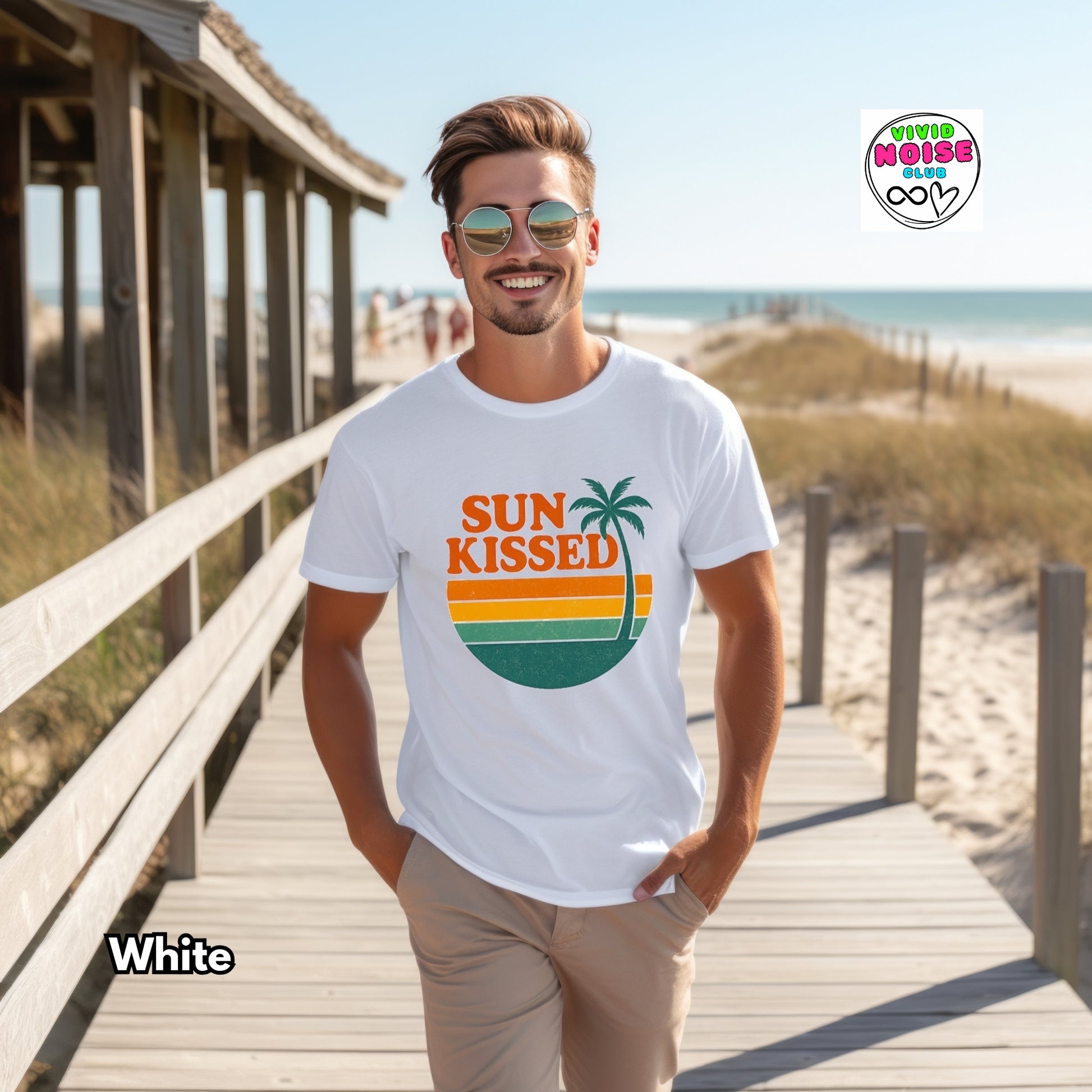 Man wearing a white t-shirt with 'Sun Kissed' design on a beach boardwalk.
