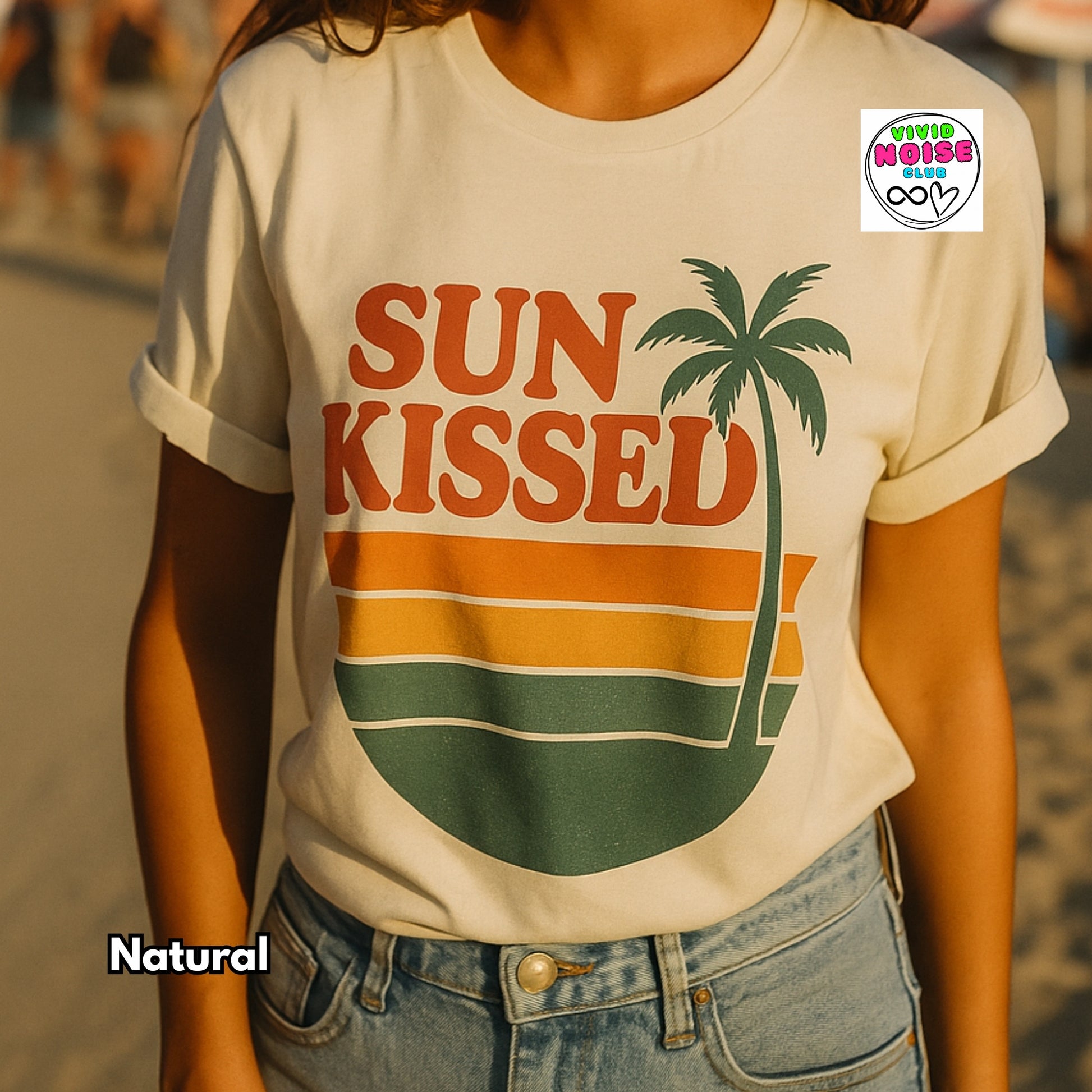 Person wearing a 'Sun Kissed' t-shirt with a palm tree graphic, standing outdoors.