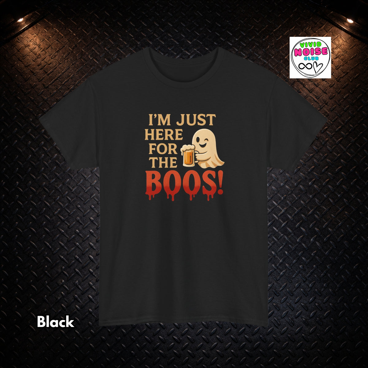 A black short-sleeve t-shirt with a graphic print that reads 'I'M JUST HERE FOR THE BOOS!' in beige and red, featuring a cute ghost holding a beer mug. The shirt is displayed on a dark textured diamond plate background with dramatic overhead lighting, a 'Black' color label in the bottom-left, and a 'Tired House Co' brand logo in the top-right.
