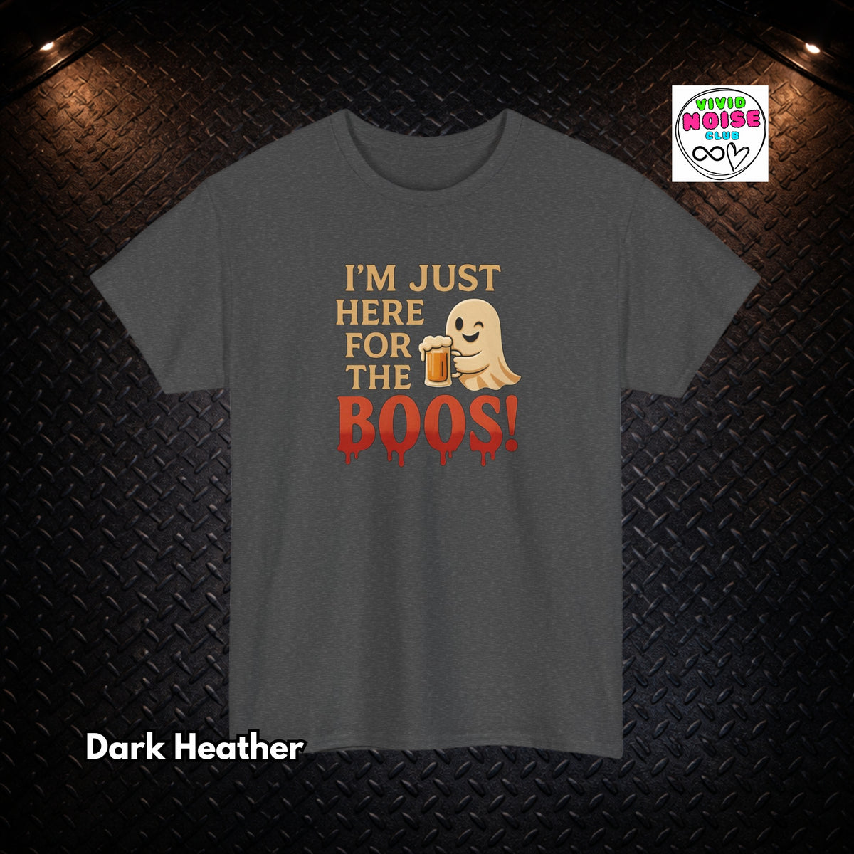 A dark heather gray t-shirt with a graphic print that reads 'I'M JUST HERE FOR THE BOOS!' in gold and red, featuring a cute ghost holding a beer mug. The shirt is displayed on a dark textured diamond plate background with dramatic overhead lighting, and a 'Tired House Co' brand logo is visible in the top right corner.