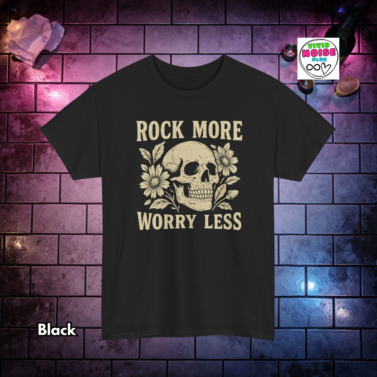 A black short-sleeve graphic t-shirt featuring a cream-colored skull and floral design with the text 'ROCK MORE WORRY LESS'. The shirt is displayed against a dark brick wall background with purple and blue lighting, with a 'Winter Noise' brand logo in the top right and a 'Black' color label in the bottom left.