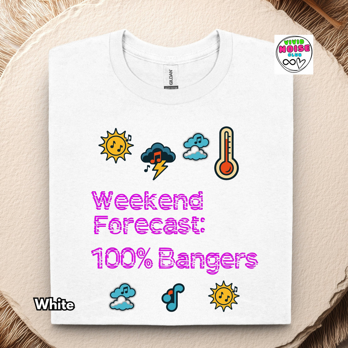A folded white t-shirt with a colorful 'Weekend Forecast: 100% Bangers' graphic print, displayed on a textured beige background with a rustic wood slice. The graphic features weather icons and pink text.