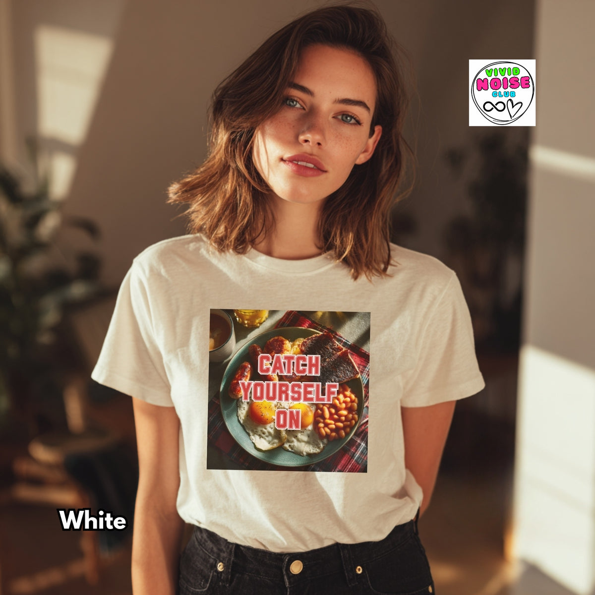 A woman wearing a white graphic t-shirt with a food-themed print that reads 'CATCH YOURSELF ON'. The image has a 'Tired of Being Awesome' sticker logo in the top right and 'White' text overlay in the bottom left.