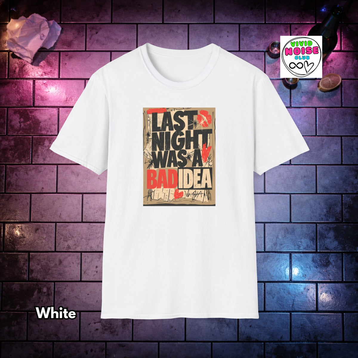 A white short-sleeve crewneck t-shirt with a graphic print on the front that reads 'LAST NIGHT WAS A BAD IDEA' in black and red text over a distressed beige background. The shirt is displayed against a dark brick wall background with purple and blue lighting, with a 'Vivid Noise Club' brand logo in the top right and the word 'White' in the bottom left.
