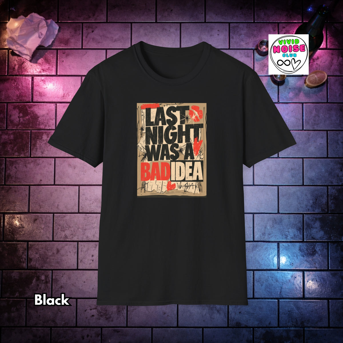 A black short-sleeve t-shirt with a graphic print on the front that reads 'LAST NIGHT WAS A BAD IDEA' in black, white, and red text over a distressed beige background. The shirt is displayed against a dark brick wall backdrop with purple and blue lighting, with a 'Vivid Noise Club' badge in the top right and the word 'Black' in the bottom left.