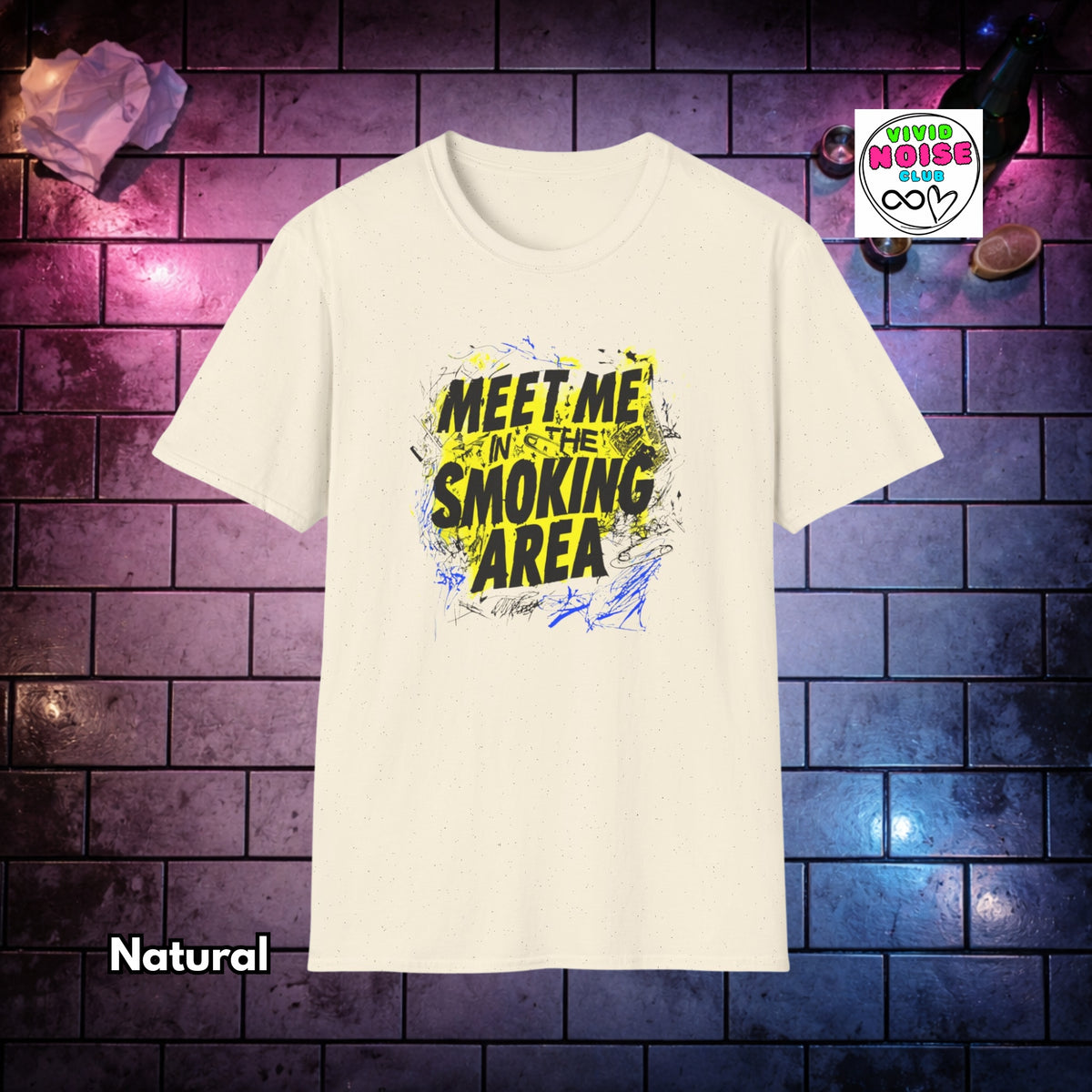 A cream-colored short-sleeve t-shirt with a bold graphic print reading 'MEET ME IN THE SMOKING AREA' in black and yellow, displayed against a dark brick wall background with purple and blue lighting. A 'Vivid Noise Club' brand logo is visible in the top right corner, and the word 'Natural' is written in the bottom left.