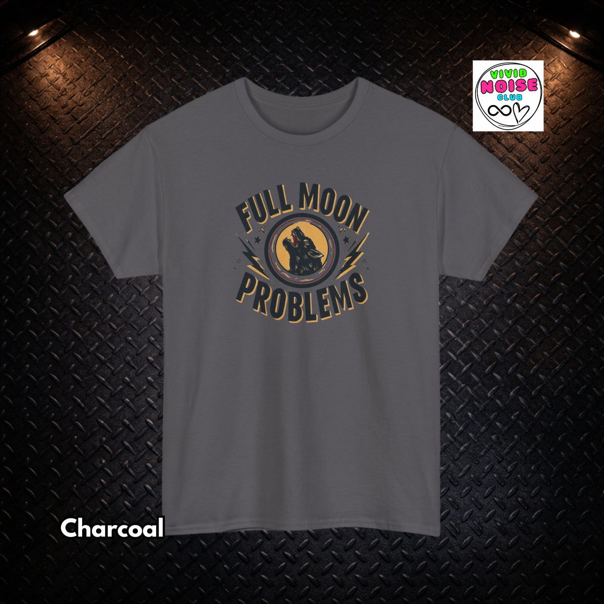 A charcoal gray short-sleeve t-shirt with a graphic print reading 'FULL MOON PROBLEMS' in a circular design, displayed against a dark diamond plate background with warm overhead lights. A 'Vivid Noise Club' logo is visible in the top right, and 'Charcoal' is written in the bottom left.