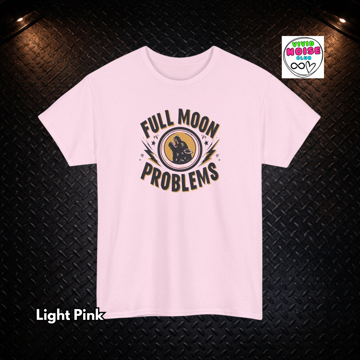 A light pink short-sleeve t-shirt with a graphic print reading 'FULL MOON PROBLEMS' around a central moon and rabbit illustration, displayed on a dark textured background with a 'Vivid Noise Club' logo in the top right and 'Light Pink' text in the bottom left.