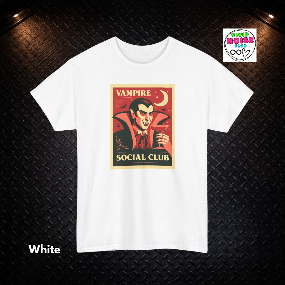 A white short-sleeve crewneck t-shirt featuring a vintage-style graphic of a vampire with the text 'VAMPIRE SOCIAL CLUB'. The shirt is displayed flat against a black diamond plate background with a 'Vivid Noise Club' brand logo in the top right and 'White' text in the bottom left.