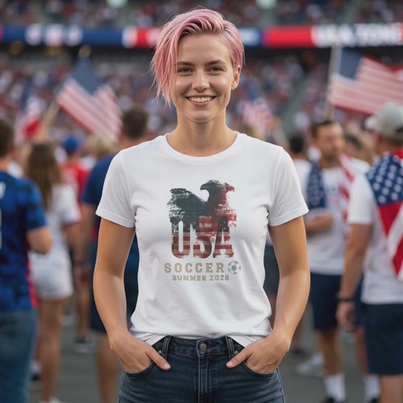 Video showing the USA Summer 2026 soccer t-shirt on a model in a match day crowd setting, featuring a retro red, white and blue supporter graphic.