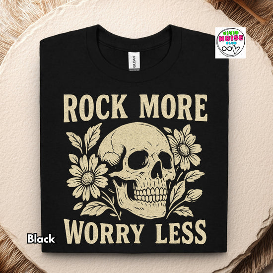 Video for a graphic t-shirt with a cream skull and floral design and the text 'ROCK MORE WORRY LESS'. 
