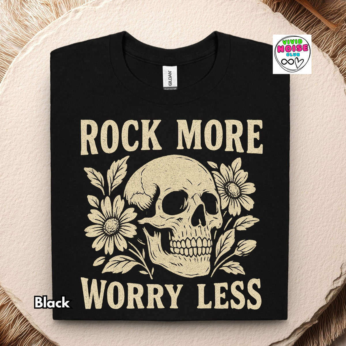 Video for a graphic t-shirt with a cream skull and floral design and the text 'ROCK MORE WORRY LESS'. 